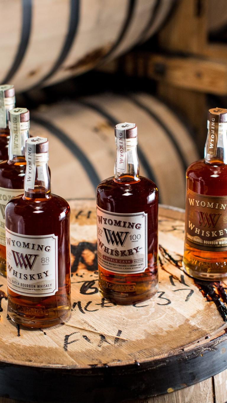five bottles on top of a cask