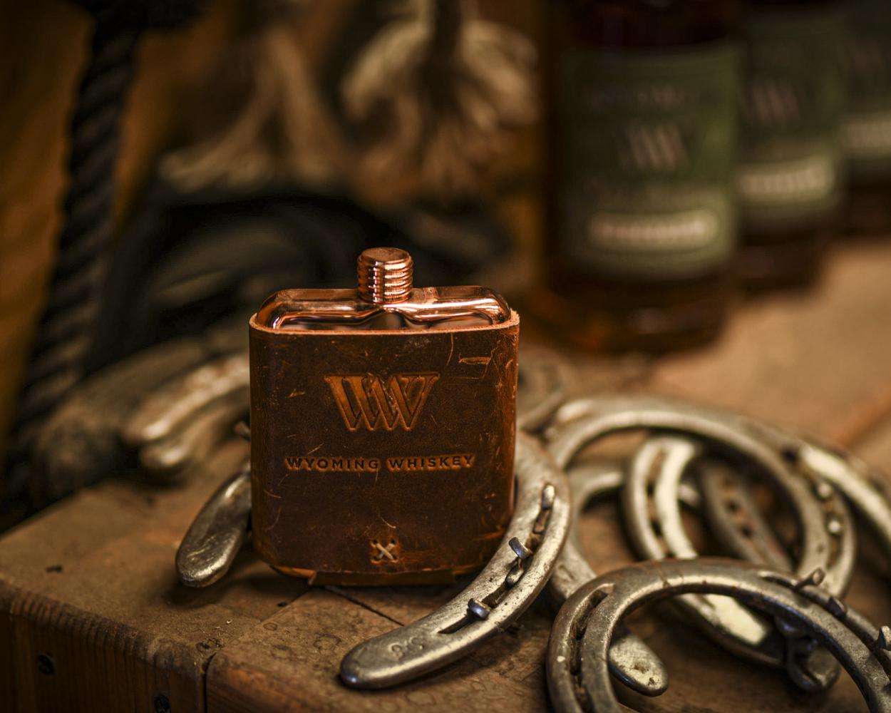 Whiskey Flask on a table with horseshoes