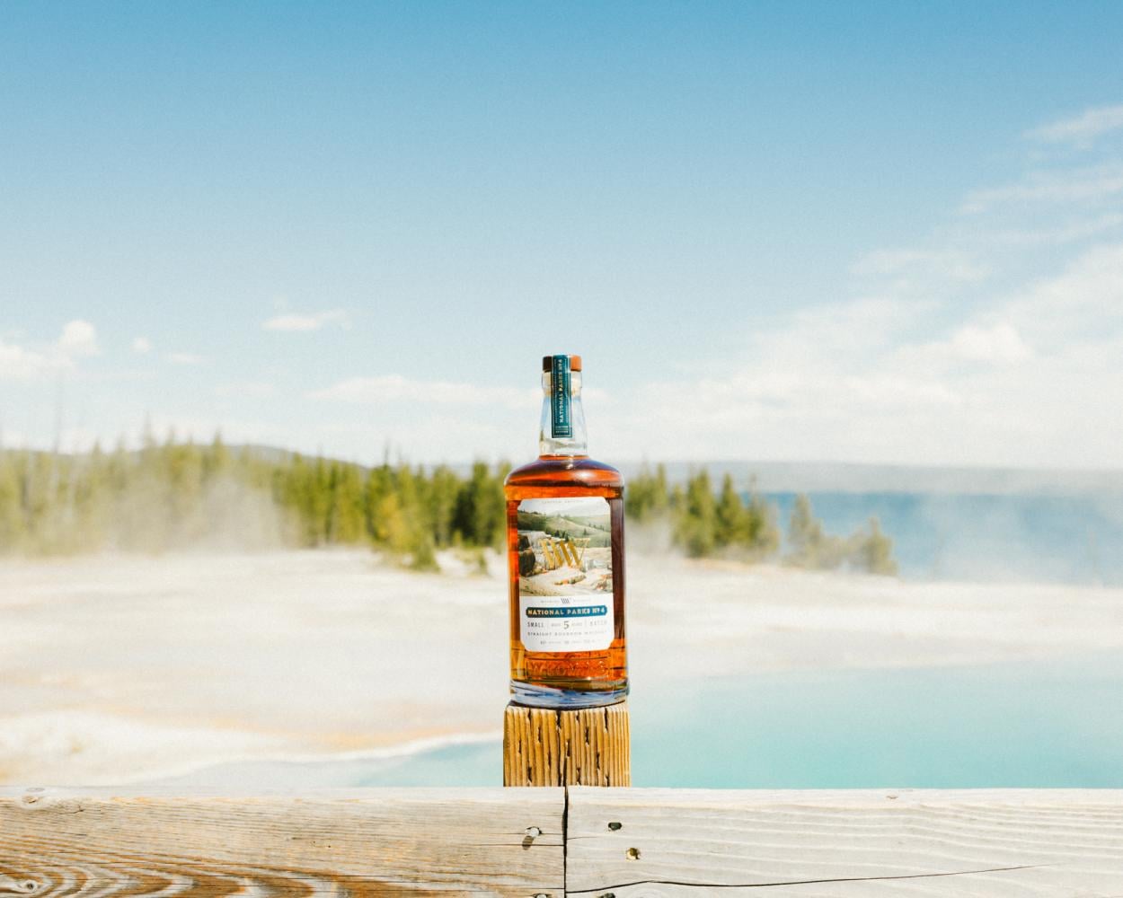 Whiskey bottle on fence post