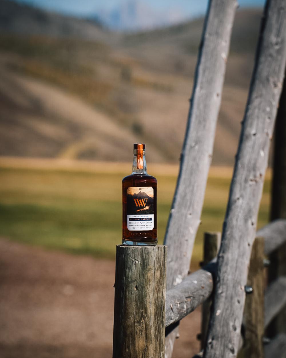 Whiskey bottle on fence post