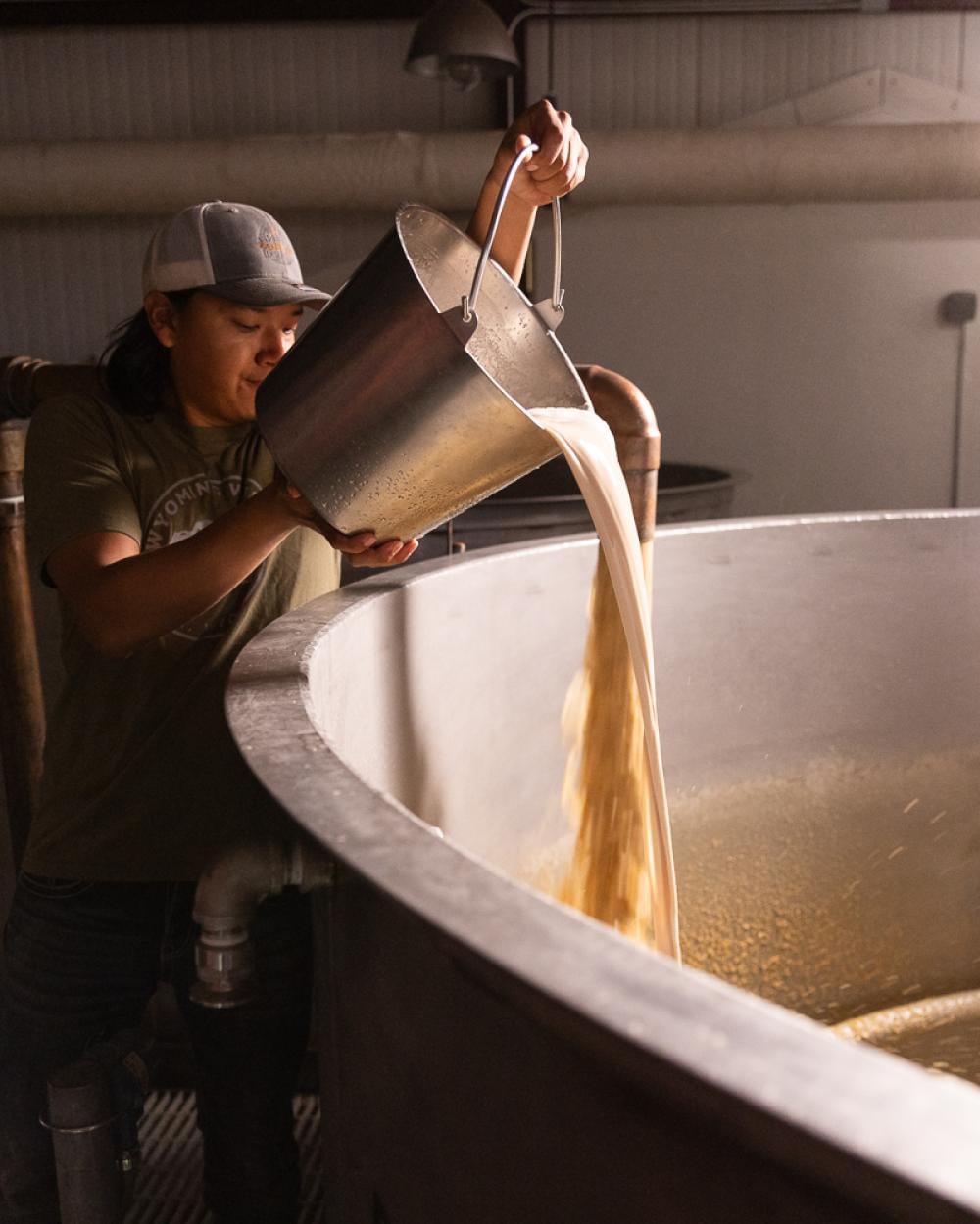 Man pouring yeast into fermenter 
