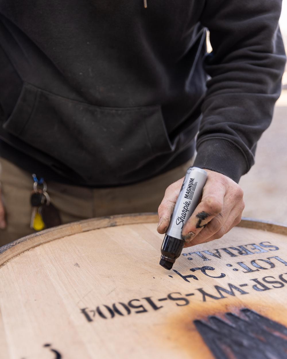 man writing on a barrel