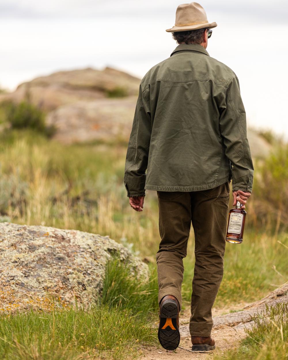 Man walking with a bottle of whiskey