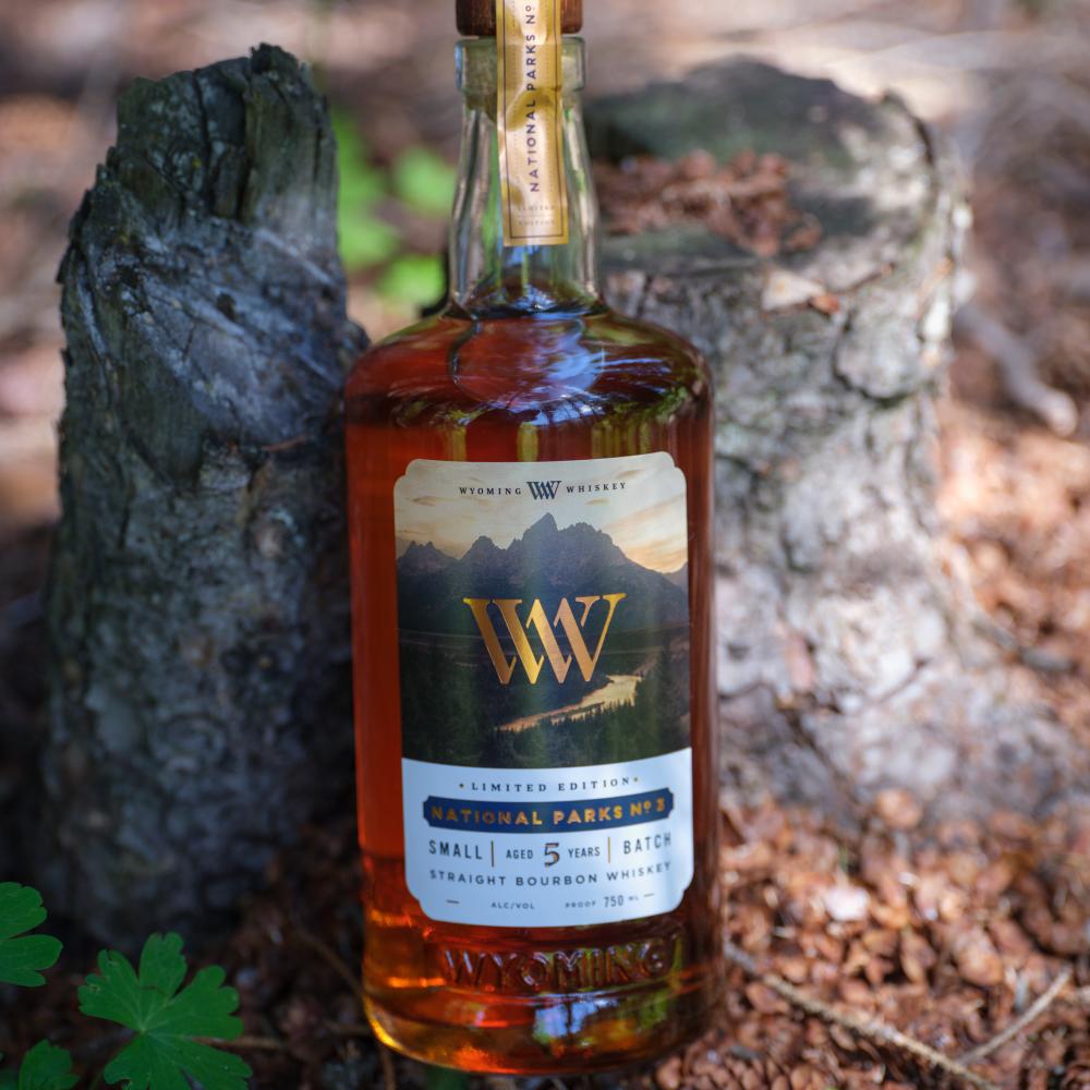 Whiskey bottle leaning against a stump