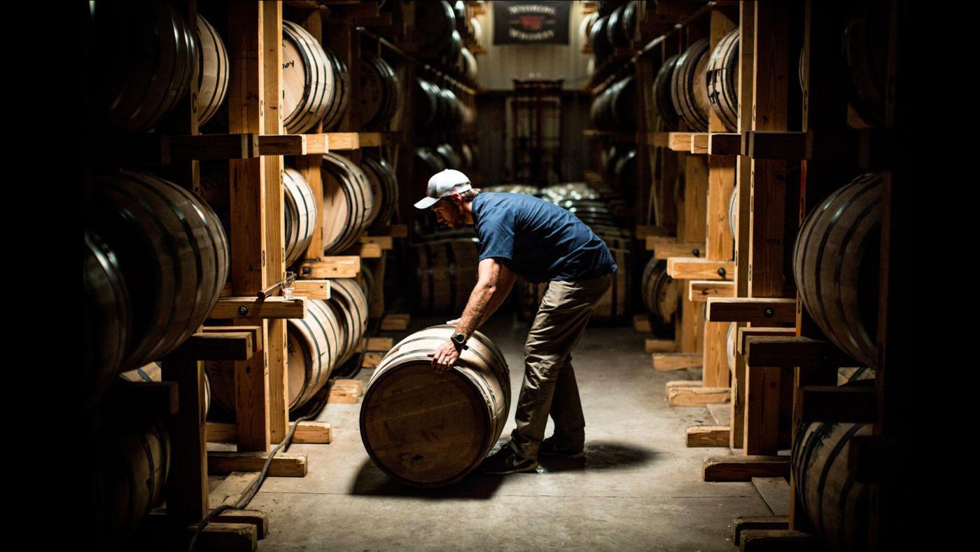 Man rolling barrel into the rack